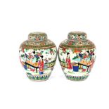 A pair of Chinese Canton ginger jars and covers, decorated with figures in exotic garden settings,