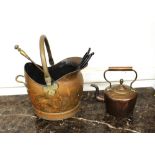 A copper coal helmet, with brass wing handle; a Victorian copper kettle and two fire implements, (