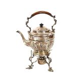 A late Victorian silver tea kettle, raised on spirit heater stand, having raised foliate decoration,