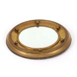 A brass convex ball, decorated porthole type mirror, 39cm dia. overall