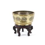 An oriental bronze incense bowl, with raised stylised motifs; and an associated lacquer stand