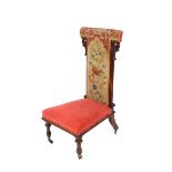 A Victorian rosewood Prie dieu, with needlepoint upholstered back, pierced foliate scroll