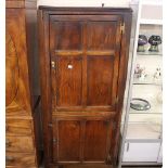 A George III East Anglian elm standing corner cupboard, the shelves enclosed by two panelled