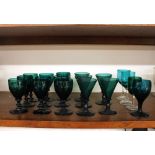 Nine Victorian green wine glasses, raised on baluster stems and circular spread feet; five conical