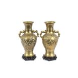 A pair of oriental brass baluster vases, with raised leaf decoration, on turned hardwood bases, 44cm
