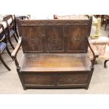 A carved oak settle, having three panel back with lozenge decoration, lifting box seat, 106cm wide