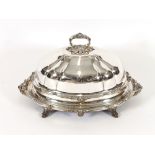 A large Victorian plated hot meat dish and cover, with acanthus decoration and raised on scrolled