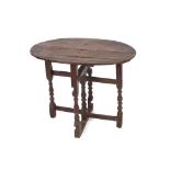 An Antique oak small gate leg occasional table, the oval top raised on turned baluster columns