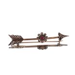 An arrow brooch, set diamonds and central flower motif with red stone