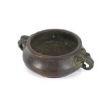 A small oriental bronze censer, having elephant head handles, seal mark to base, 14cm dia.