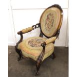 A Victorian carved walnut framed armchair, with needlepoint upholstered back and serpentine seat,