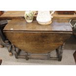 An 18th Century oak gate leg dining table, of joined construction, raised on turned baluster columns