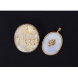 An oriental carved mother of pearl brooch, set to a yellow metal mount; and an oval yellow metal and