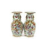 A pair of Chinese Canton baluster vases, decorated panels depicting figures in interiors, surrounded