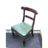 A set of four William IV mahogany dining chairs, having carved bar backs, green leather