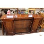 A 19th Century mahogany side cabinet, surmounted by a brass rail, central shelves flanked by