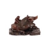An oriental carved hardwood figure of a recumbent buffalo, with figure on it's back, on pierced