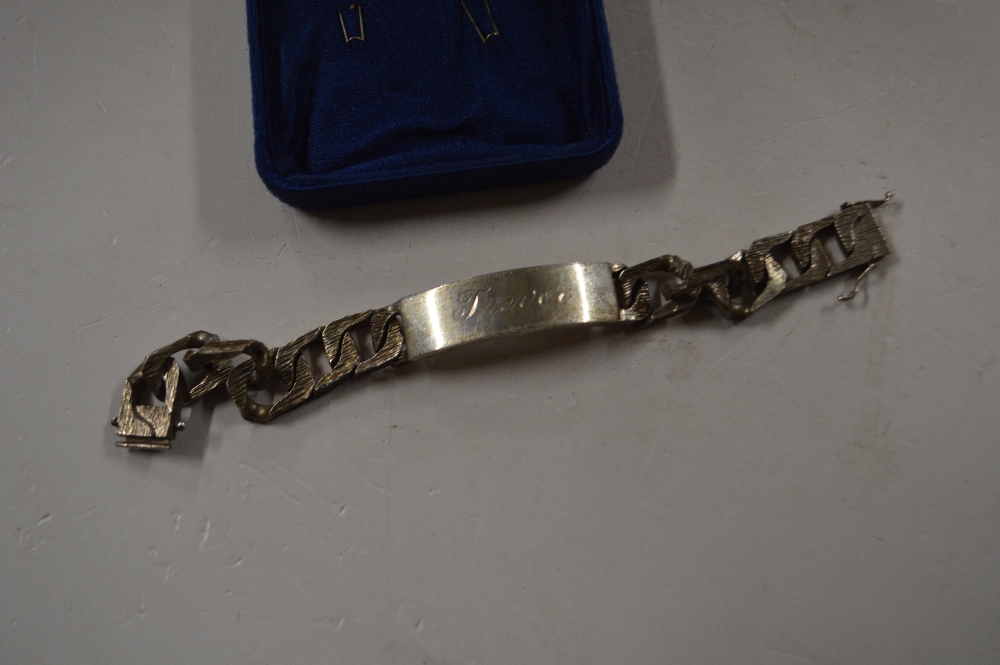 A heavy silver and white metal ID bracelet