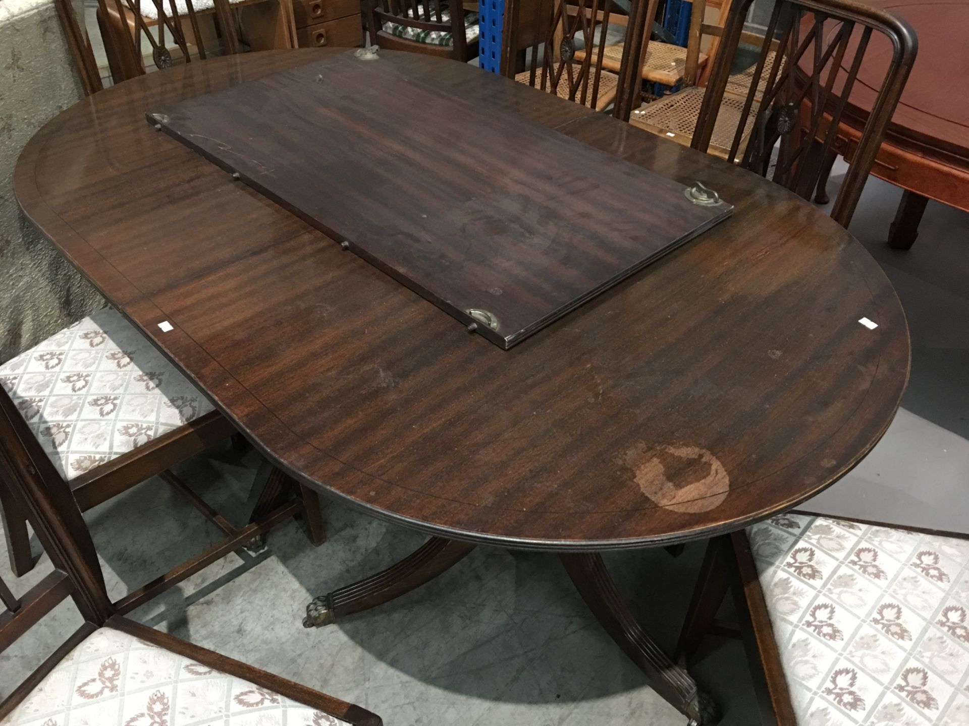 A mahogany extending dining table with one centre leaf,