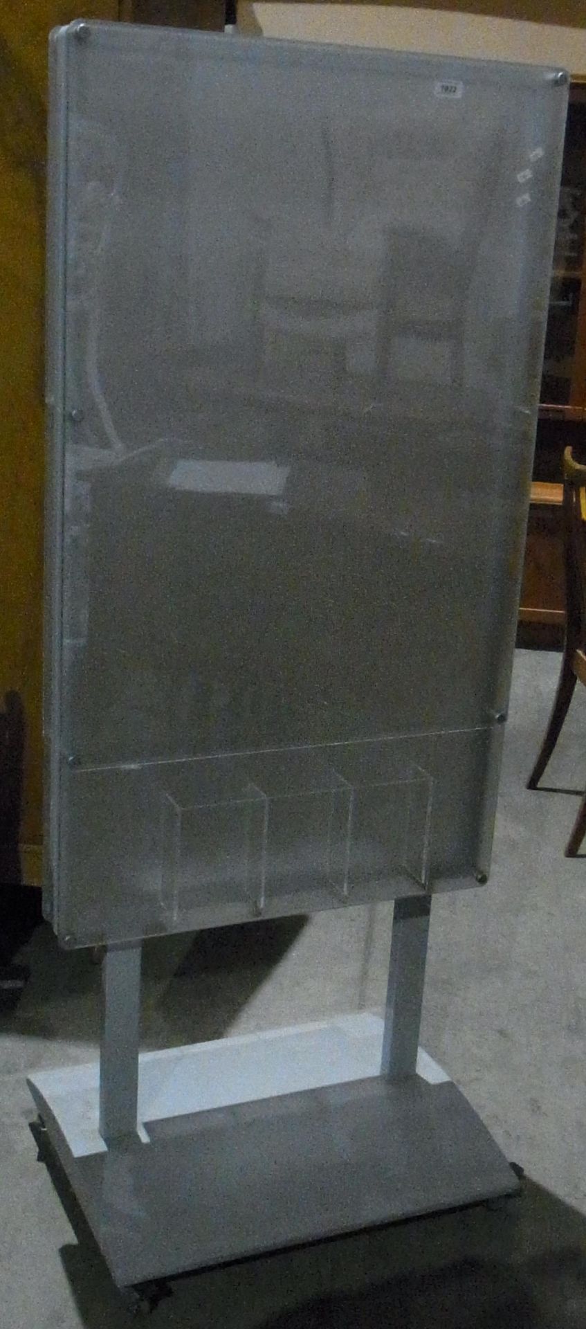 A clear plastic freestanding notice board on grey metal base