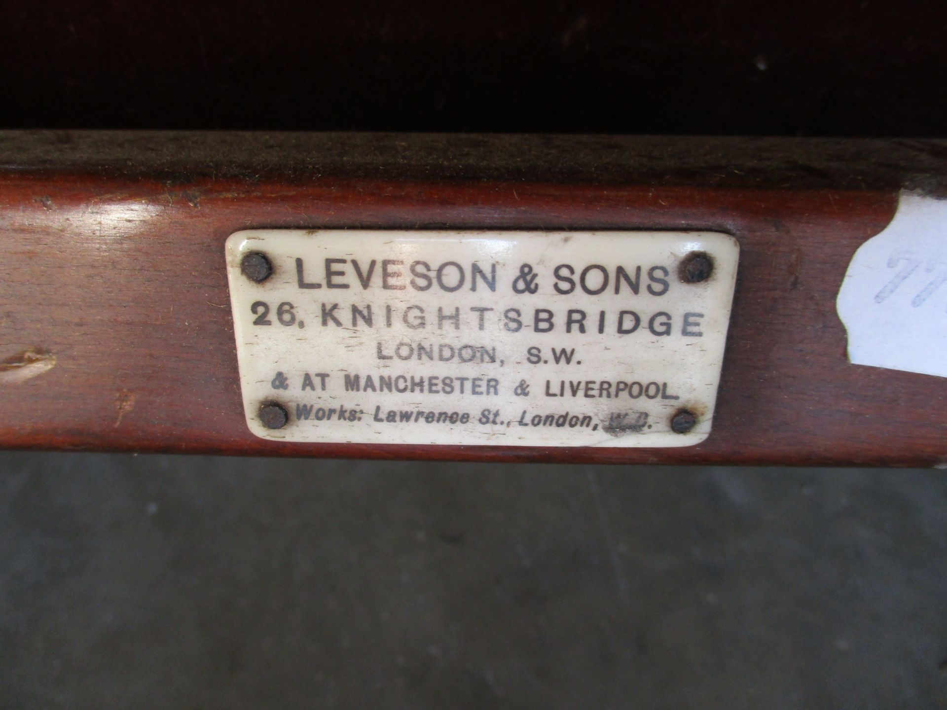 A Victorian invalid chair recovered in red velvet raised on brass wheels and labelled Leveson and - Image 6 of 6