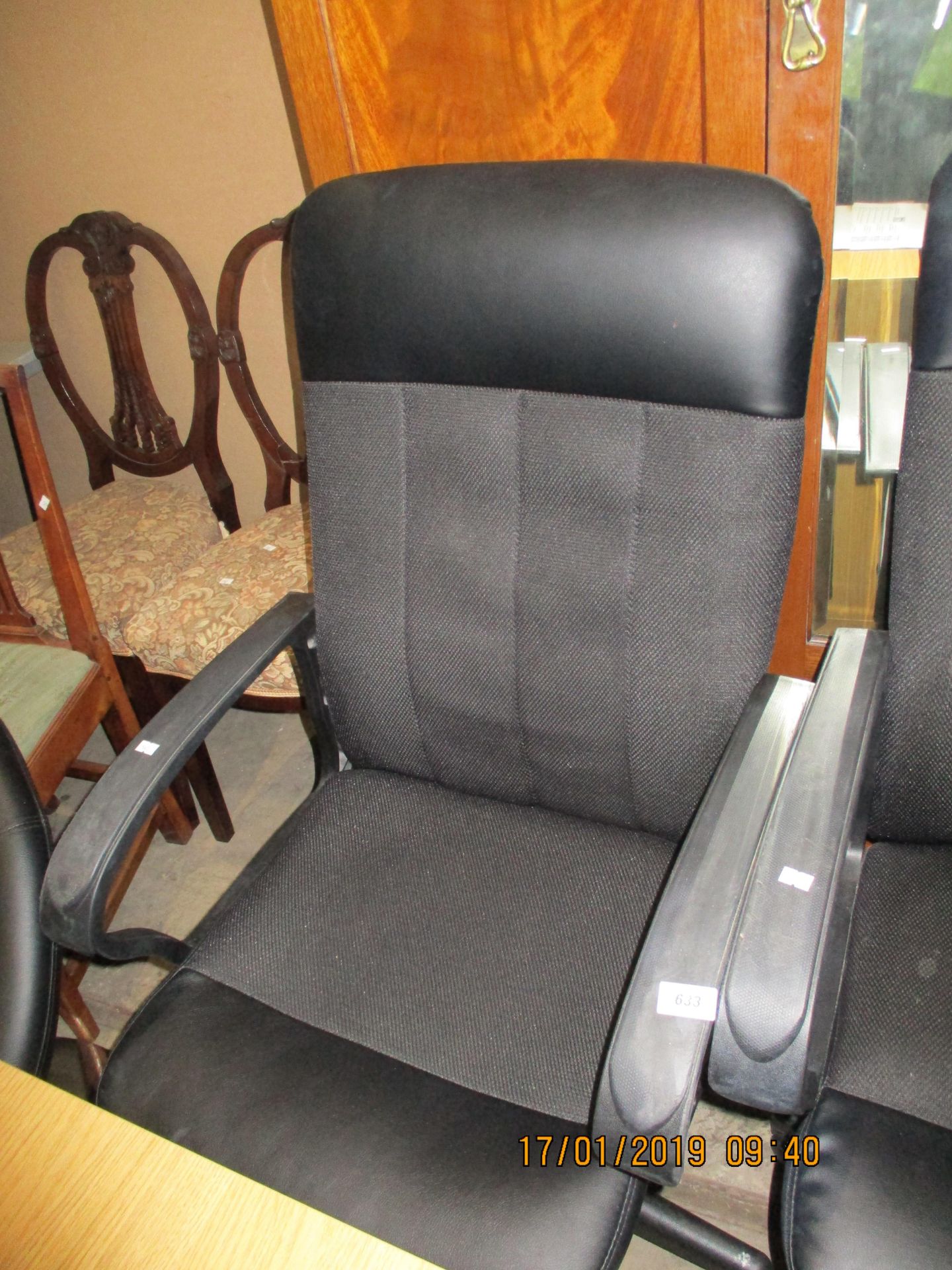 A black leather/fabric upholstered operators swivel armchair