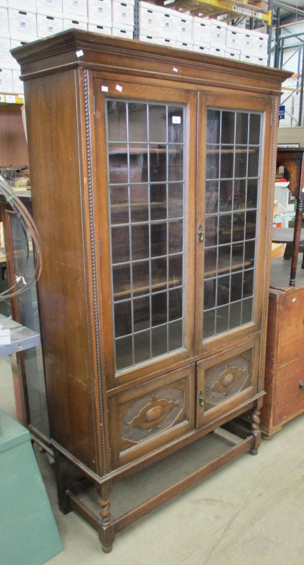 A carved oak bookcase with two leaded glazed doors over 2 door base 100 x 184cm high