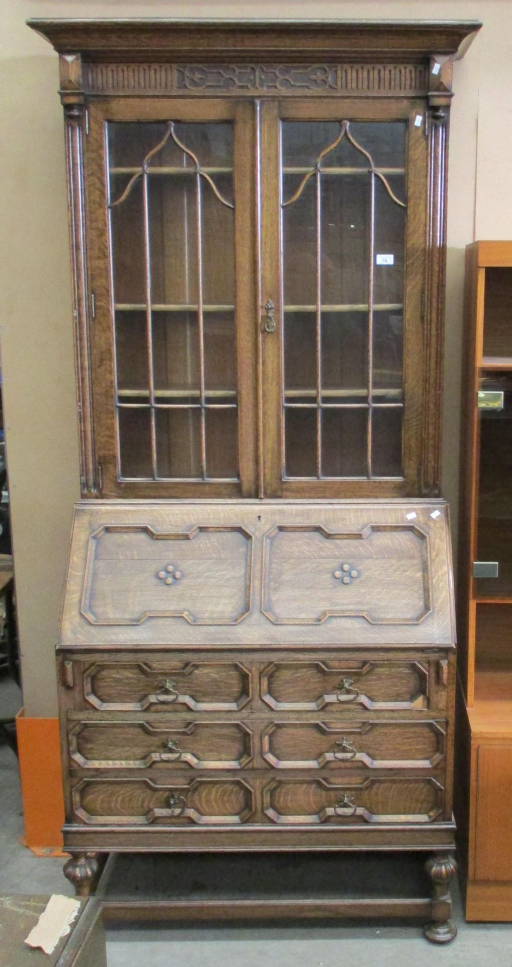 A carved oak bureau bookcase with fitted interior with double glazed doors over fall flap 3 drawer