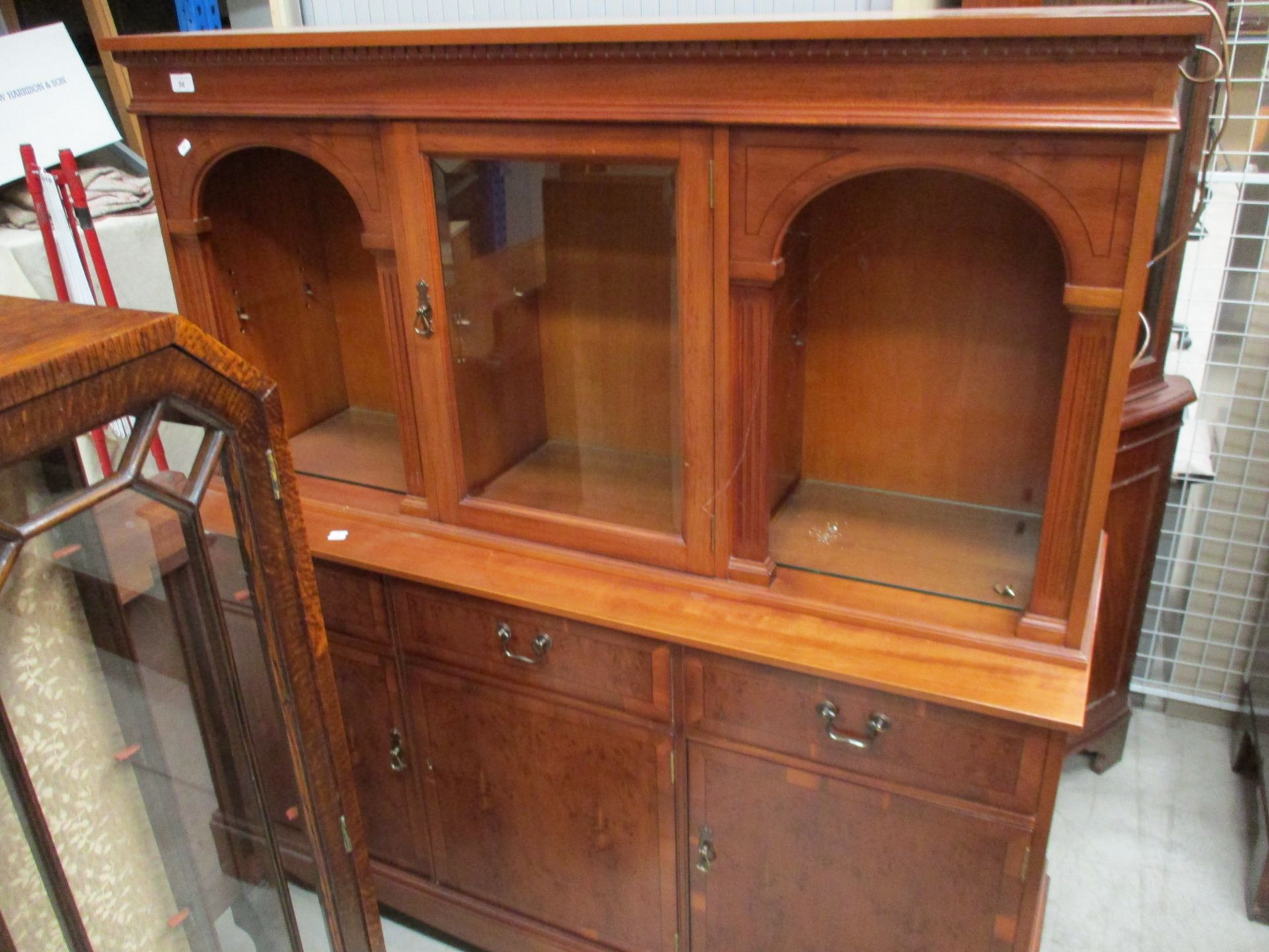 A yew wall unit with upper partially glazed section over three drawers, three door base,