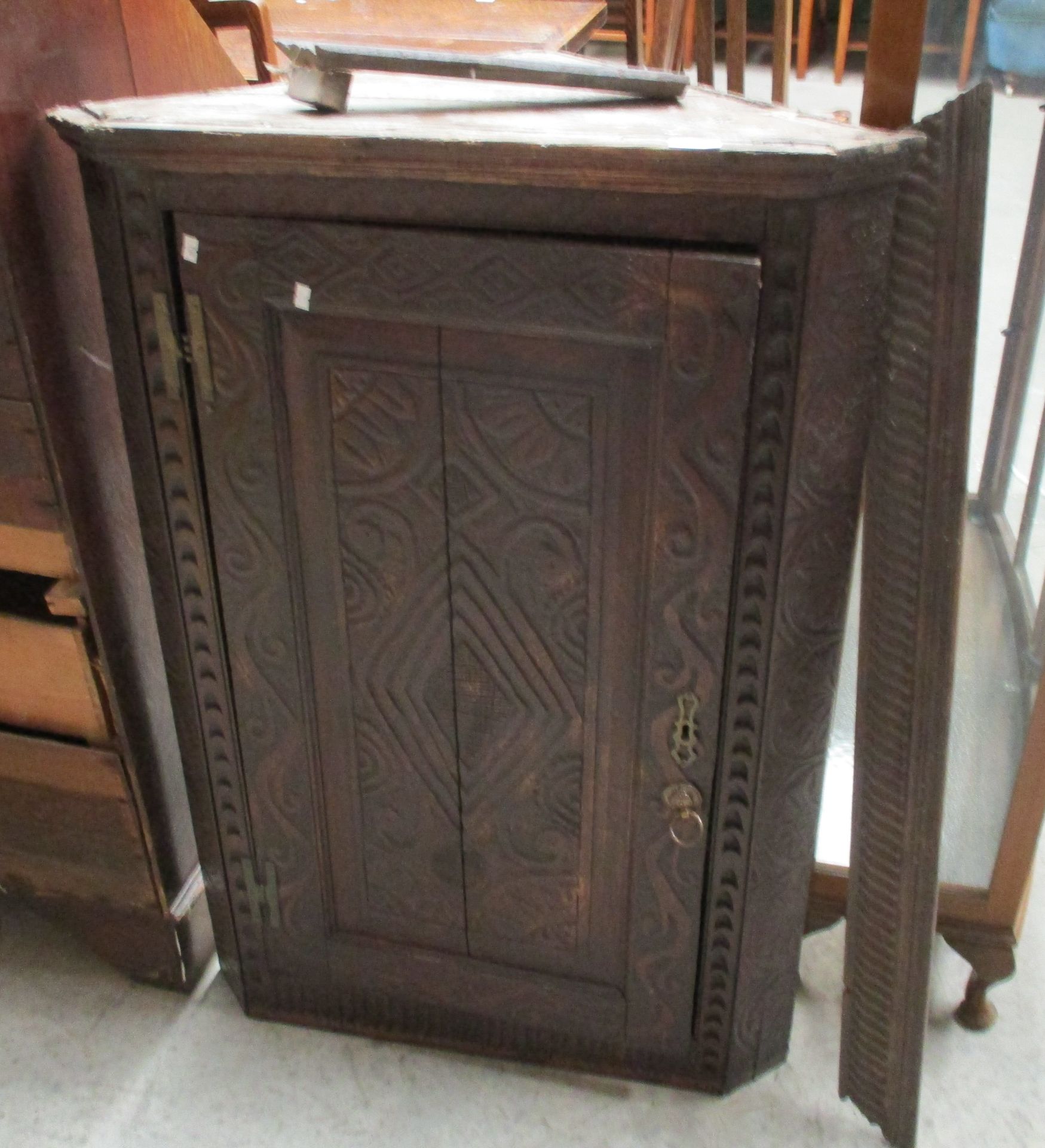 A carved oak single door wall hanging corner cabinet,