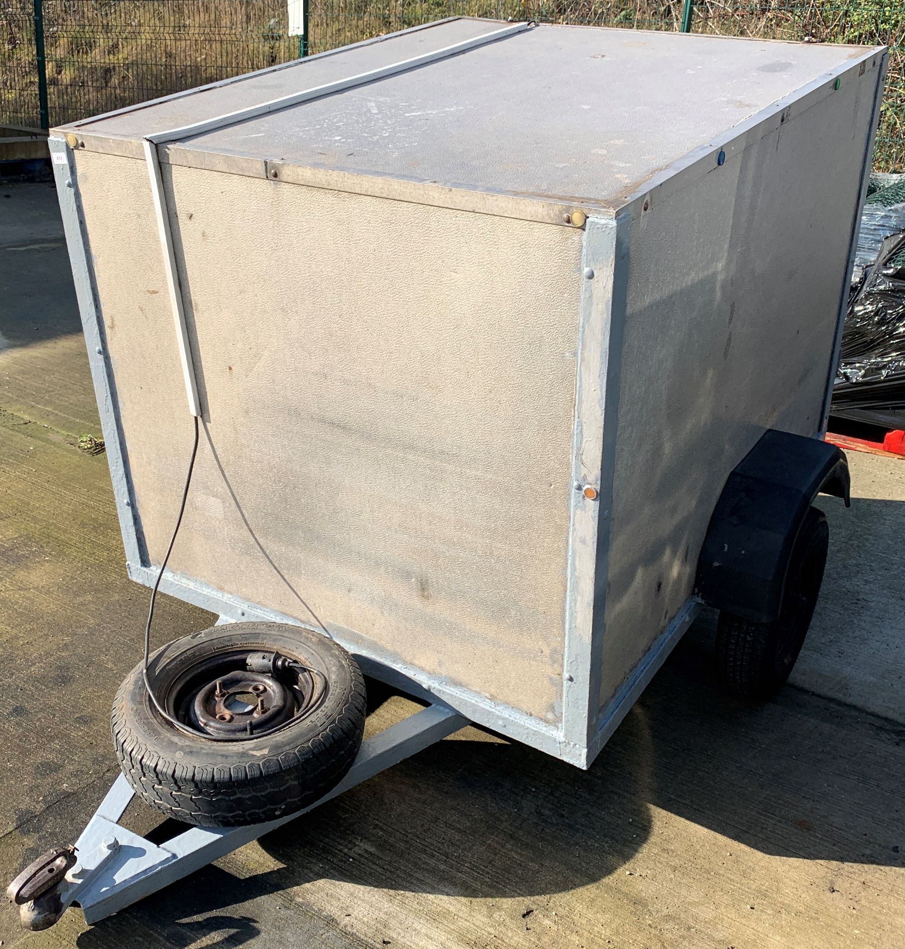 A metal framed single axle box trailer 120 x 54 x 110 cm high complete with spare wheel and key for