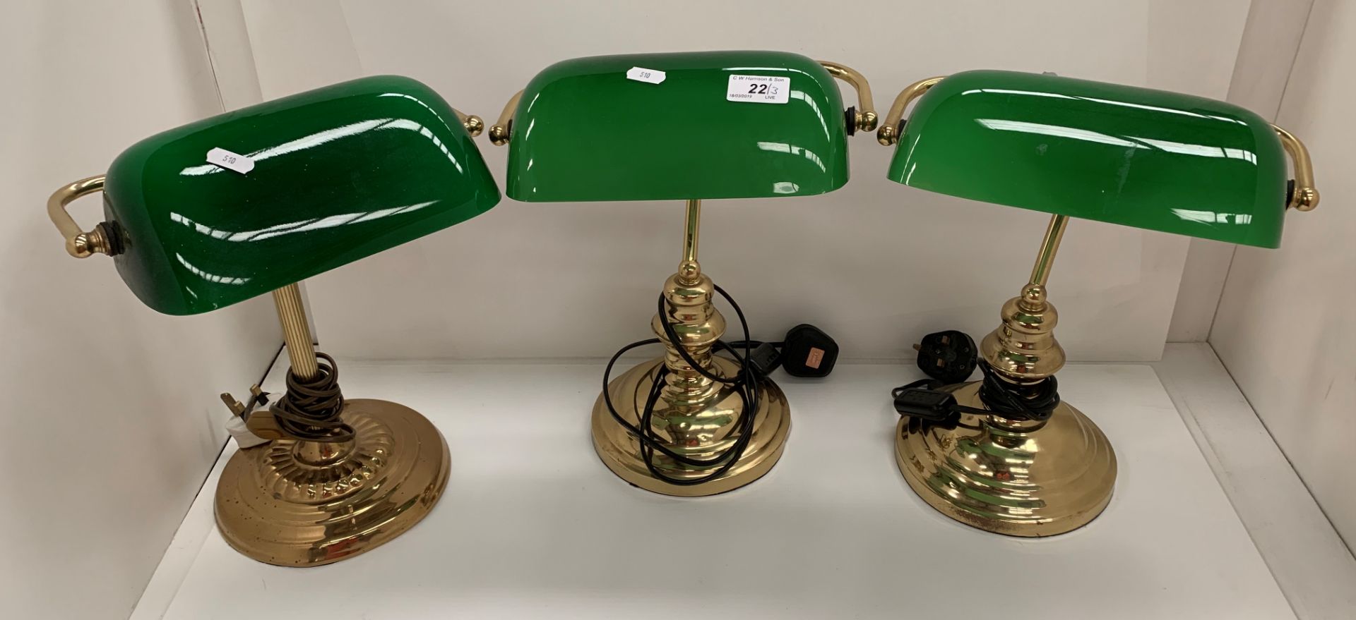 Three brass table lamps with green glass shades