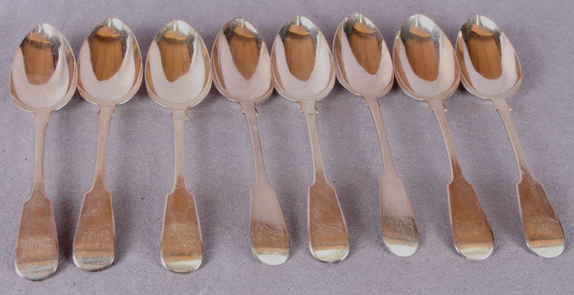 A set of eight William IV silver fiddle pattern table spoons, engraved cursive initials,