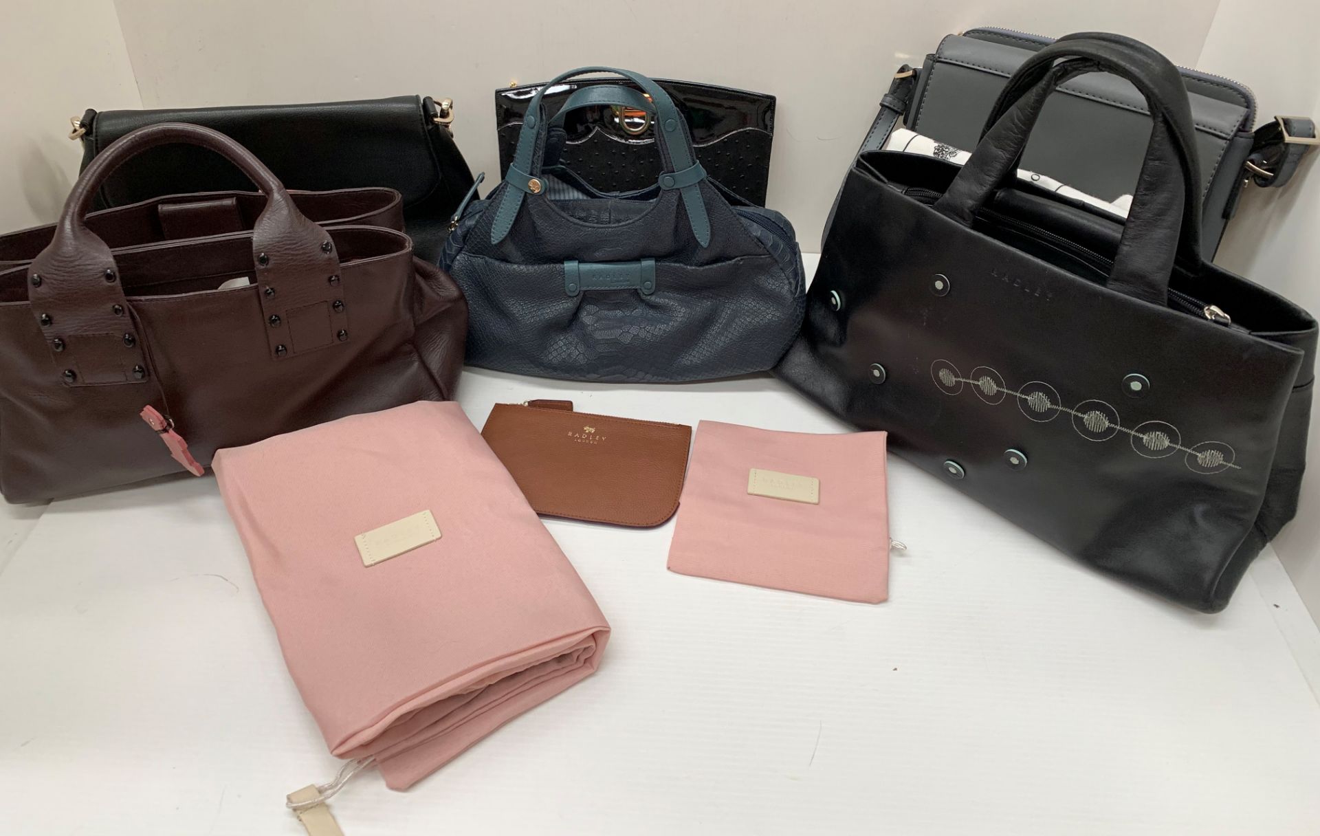 Three Radley handbags and a Radley purse together with two other handbags