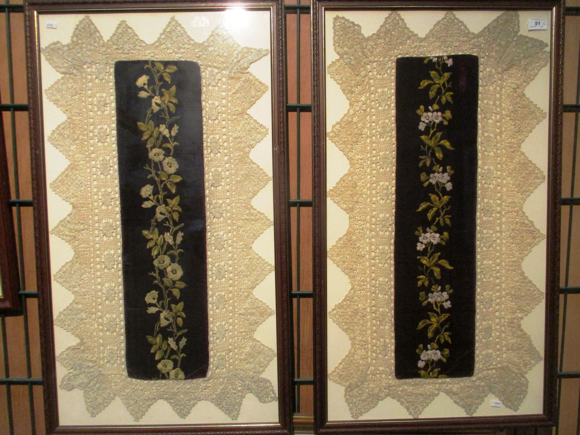 A pair of linen and velvet framed floral designed pictures