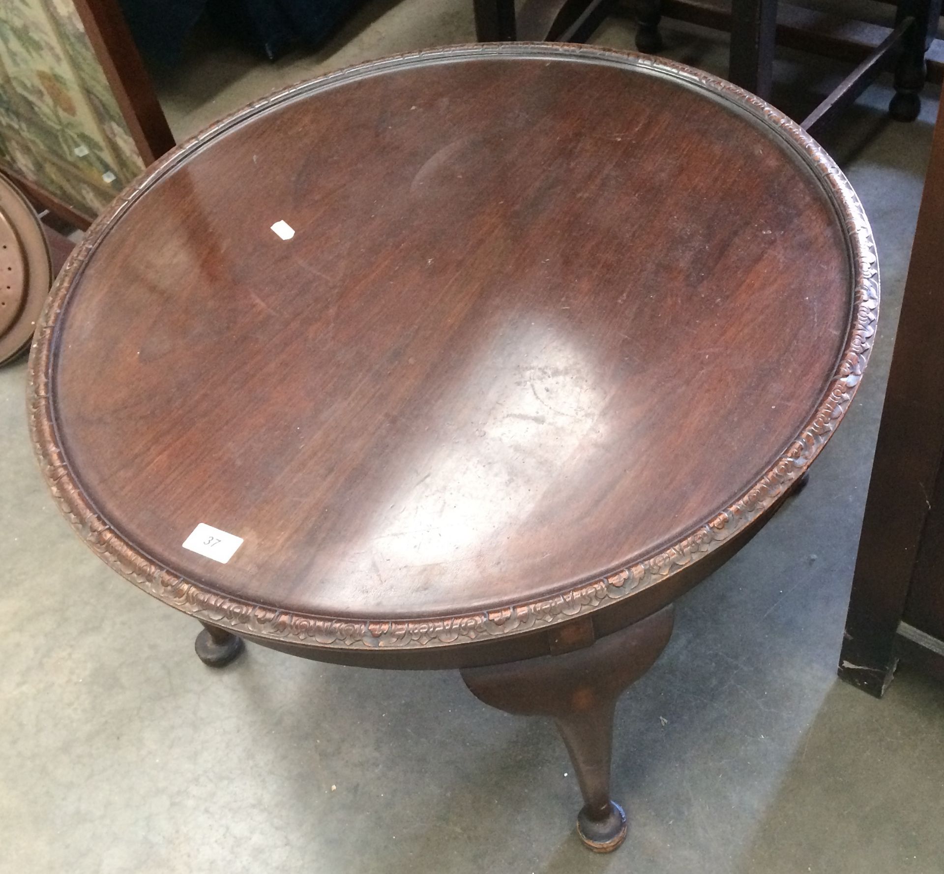 A circular mahogany acanthus leaf carved edge coffee table on cabriole legs