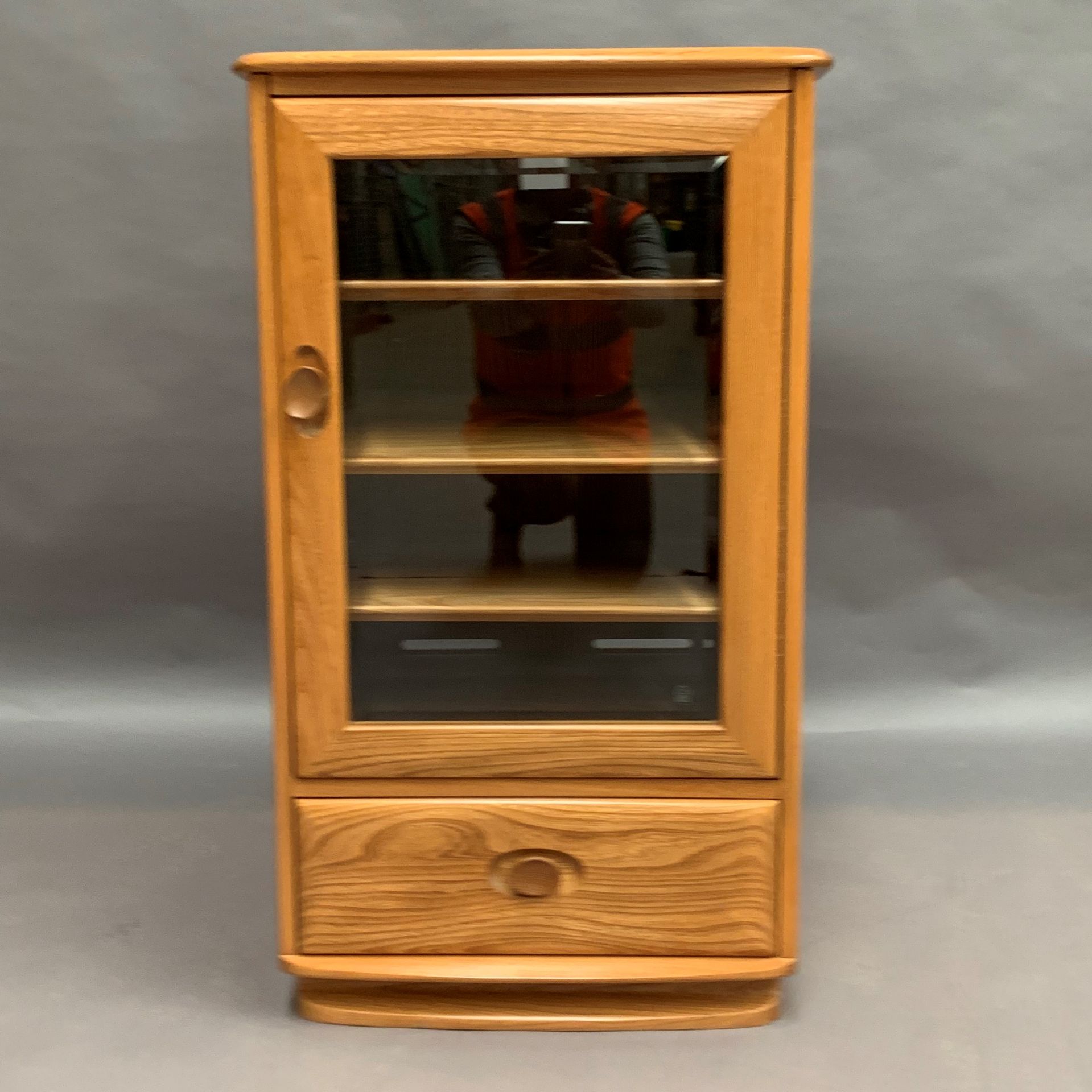 An Ercol blonde elm mobile stereo cabinet with glass door and single drawer with lift top 56 x 48 x