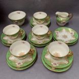 Coalport, for Harrods, tea set in green and gilt with rose motif, five cups and six saucers,