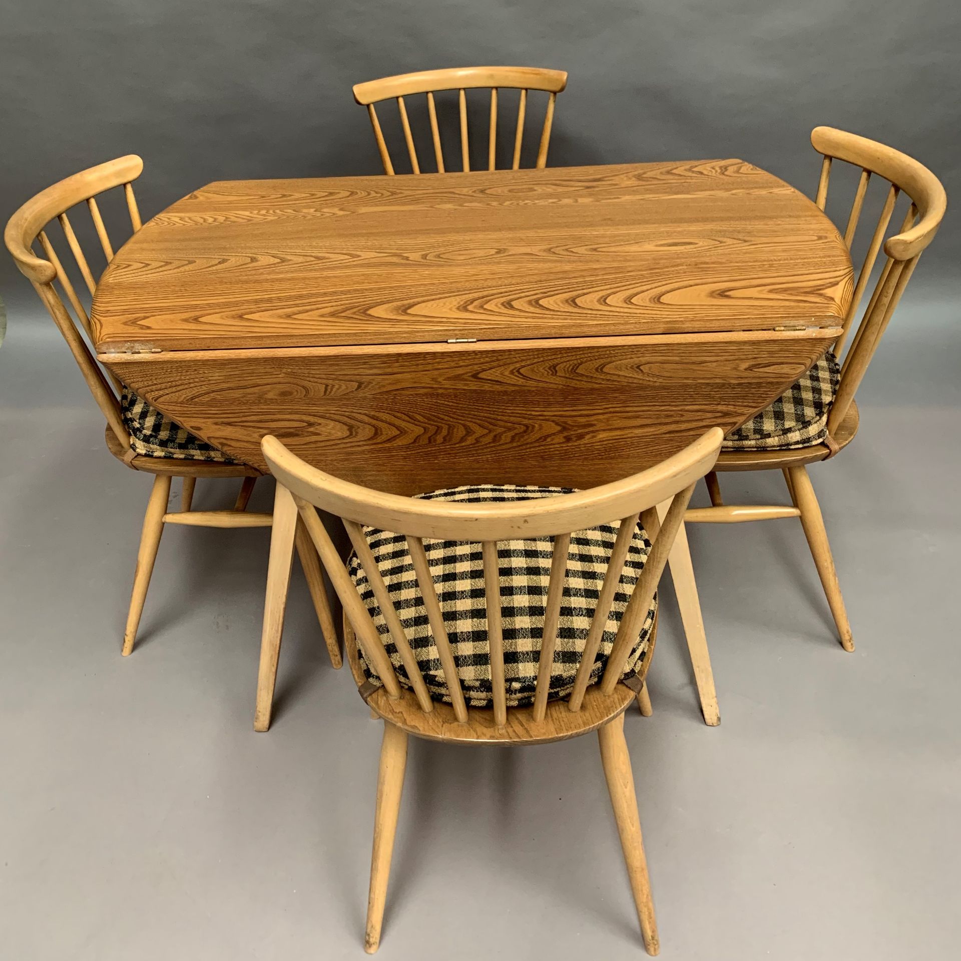 An Ercol blonde elm drop leaf dining table 113 x 125cm extended together with four Ercol stick back