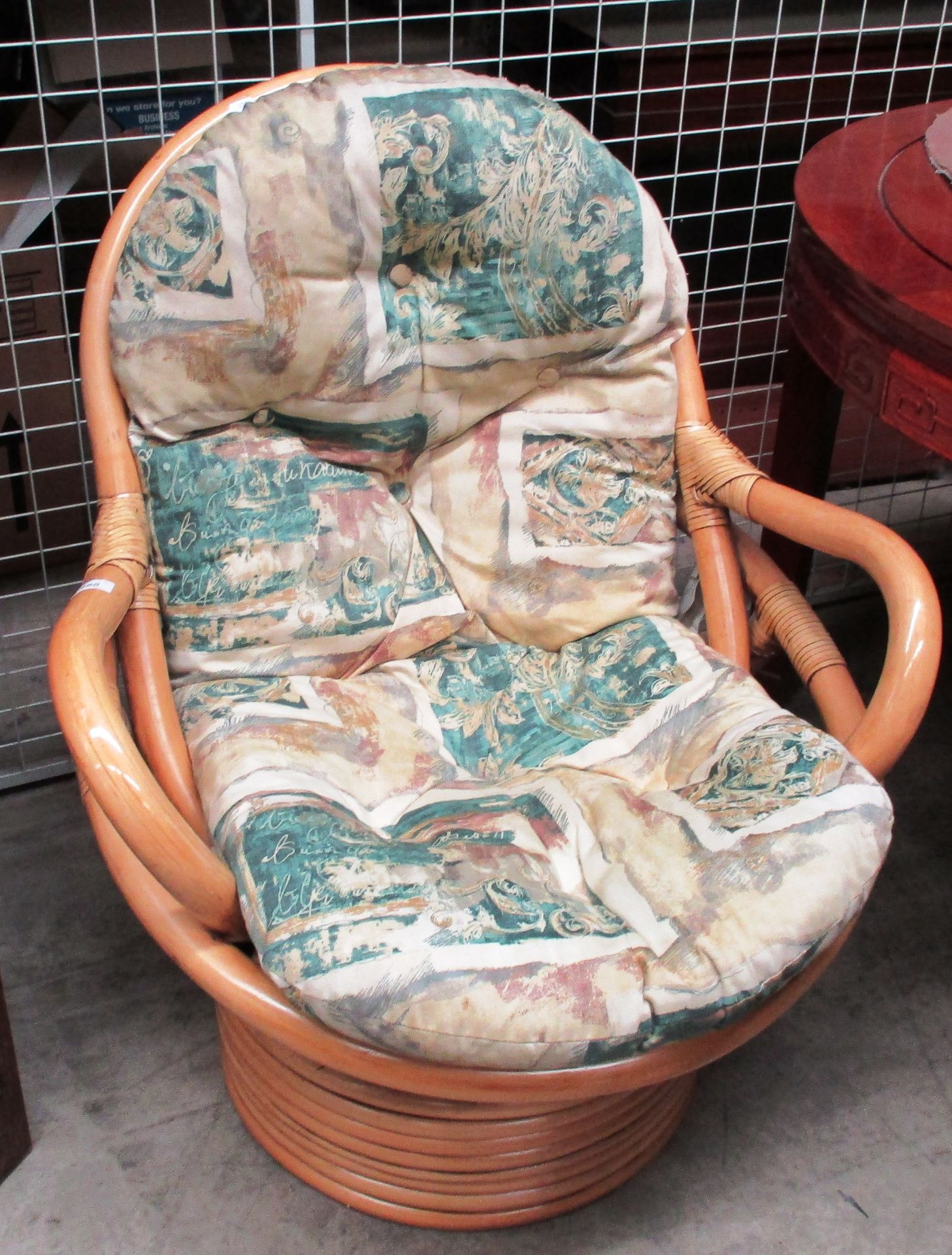 A bamboo framed swivelling/reclining conservatory armchair with patterned cushion