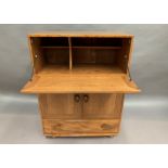 An Ercol blonde elm mobile drinks cabinet with fall flap over two door single drawer base 82 x 45 x