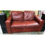 A brown leather two seater settee