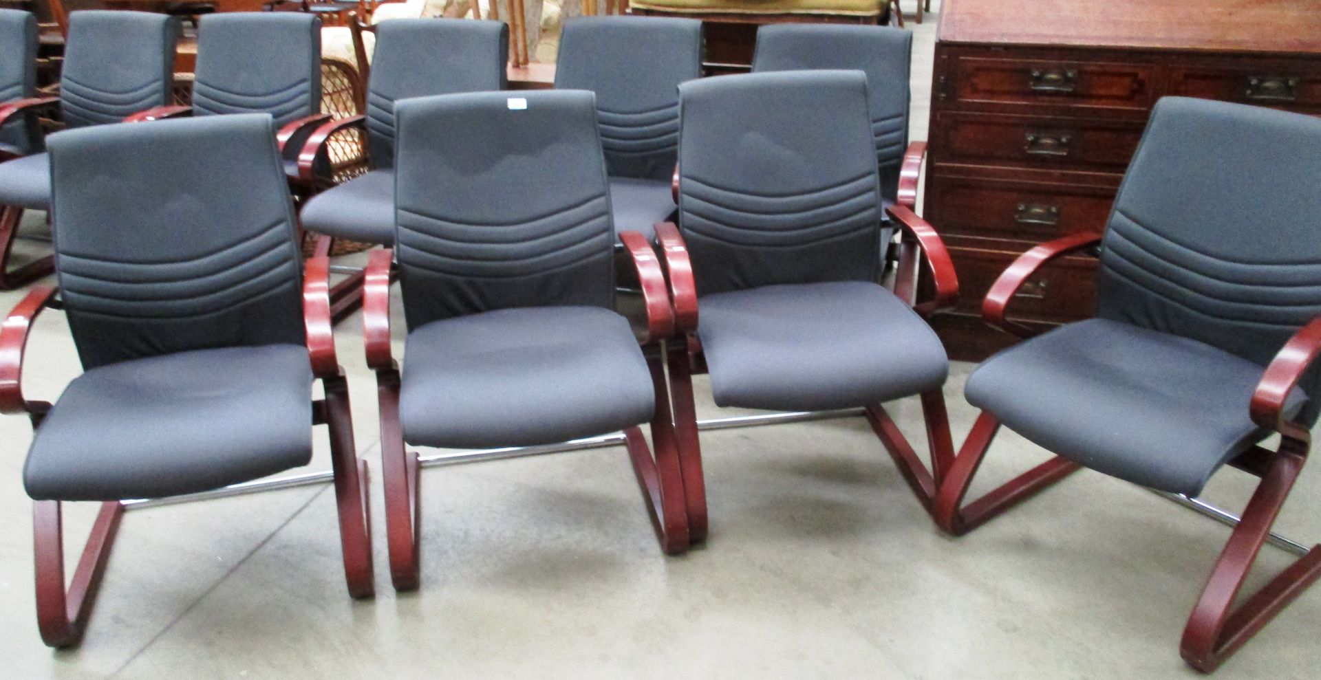 A set of four boardroom armchairs with rosewood stained arms and a mid grey upholstered seats and