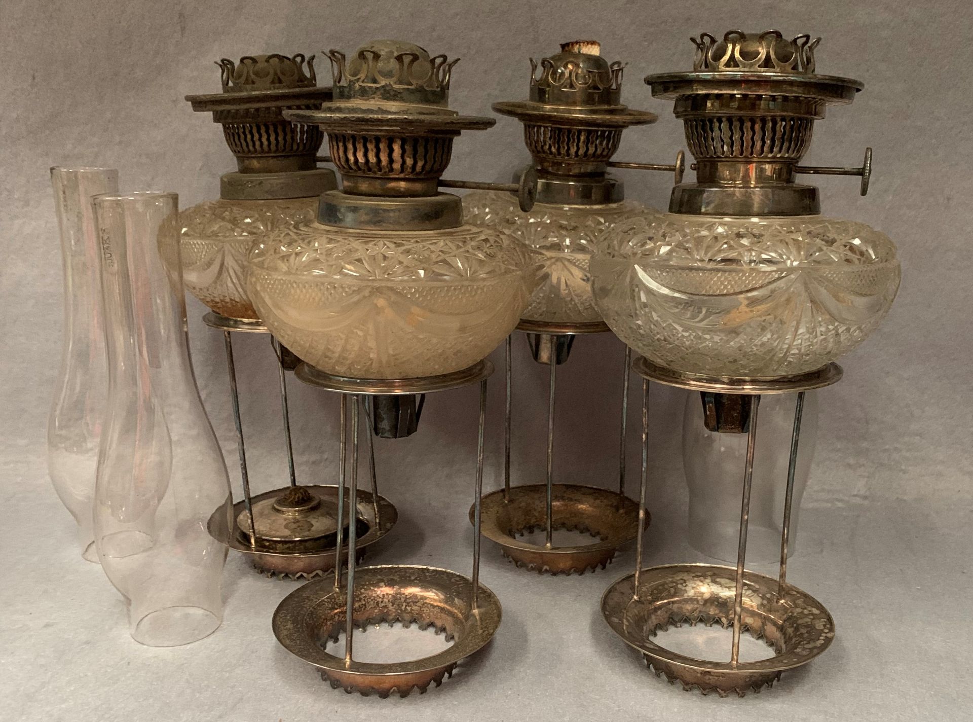 Four glass and silver plated candle holders with mounts and three funnels labelled Hinks and Son