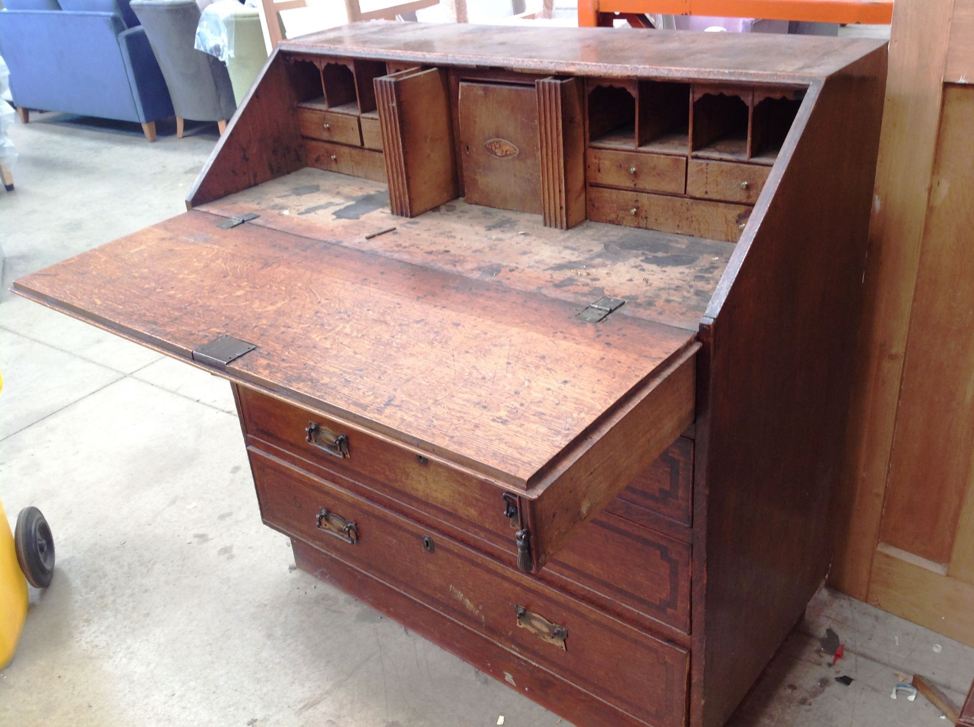 An oak bureau bookcase with fall flap over two short and three long drawers 113cm long