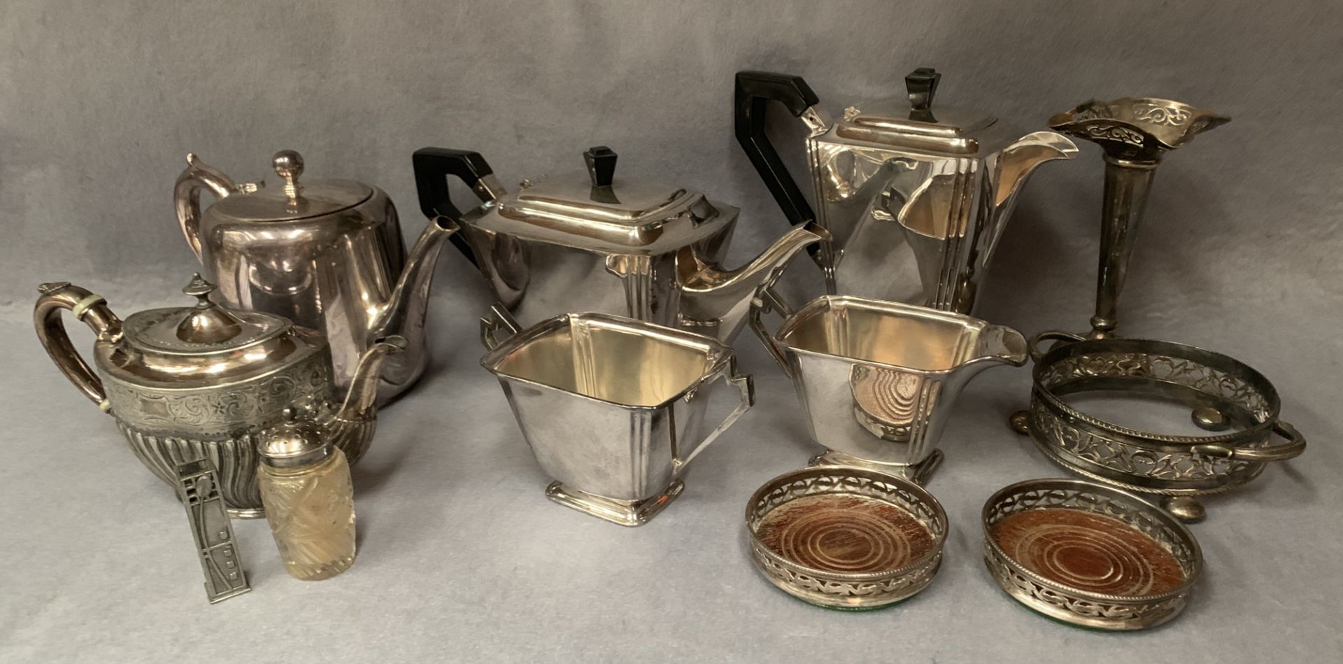 An Art Deco four piece tea service and other plated wares including coasters, teapots, flower tube,