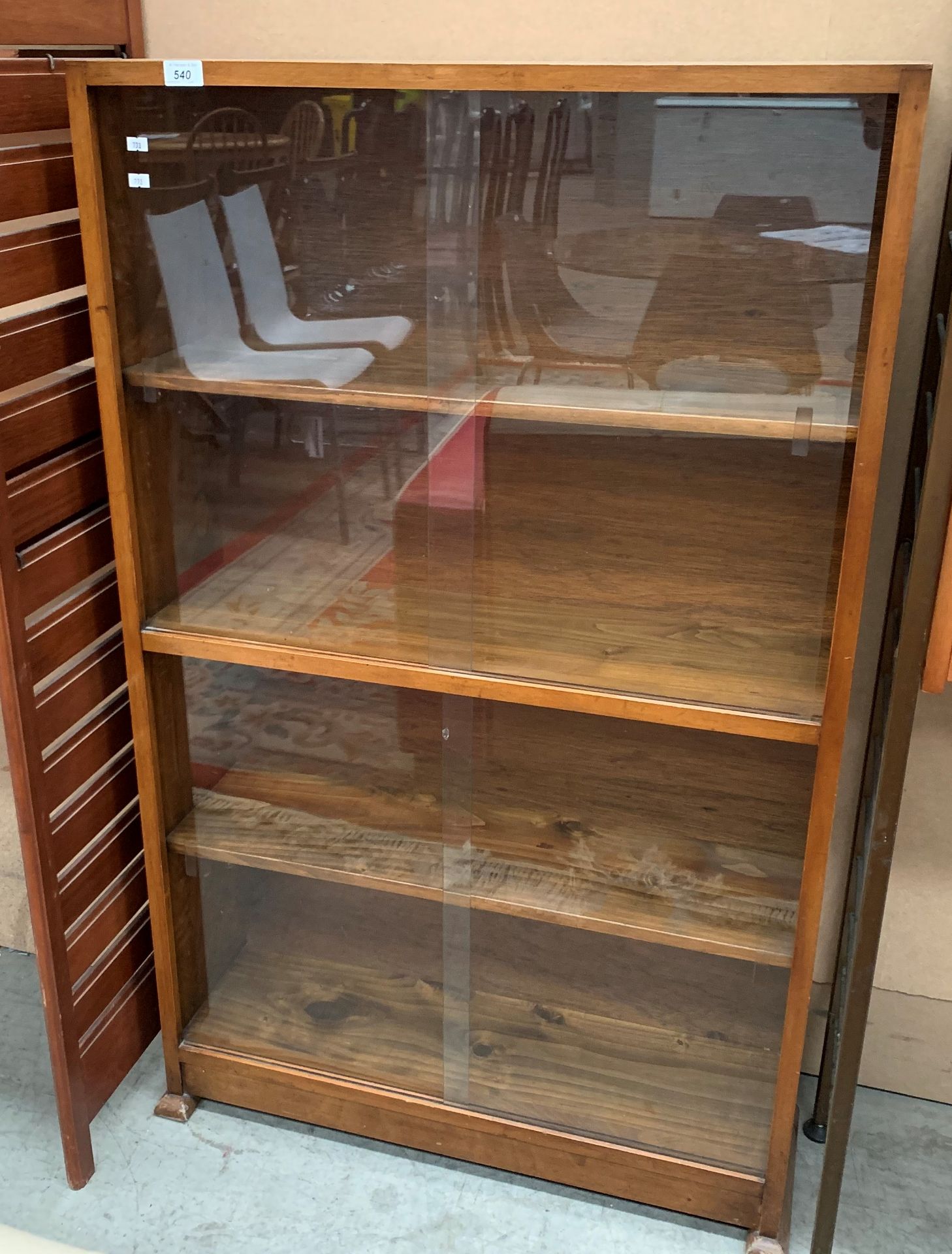 A teal four shelf bookcase with glass sliding doors 76 x 124cm high