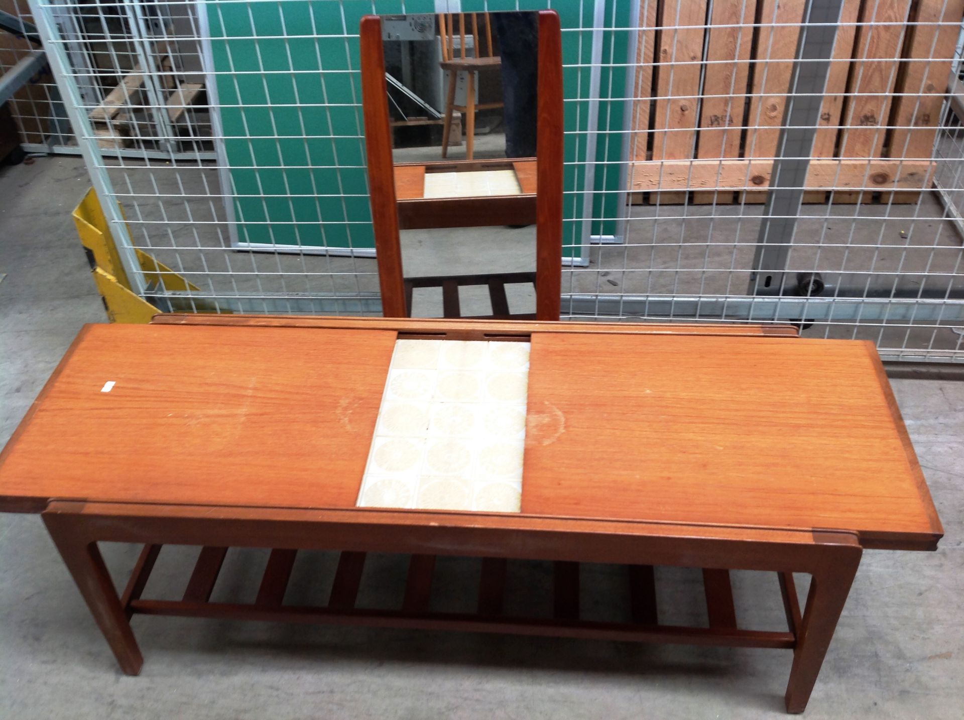 A teak coffee table with under tray and sliding top which reveals a tiled top and a teak framed