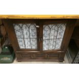 An oak two door glazed front,