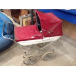 A Silver Cross pram in white with red hood and cover